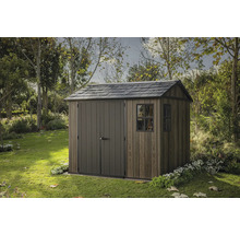 Drevený záhradný domček s dvojkrídlovými dverami a oknom v záhrade.