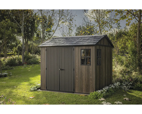 Drevený záhradný domček s dvojkrídlovými dverami a oknom v záhrade.