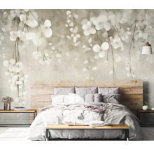 Spálňa s fototapetou s motívom listov nad drevenou posteľou