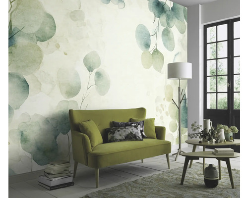 Obývacia izba so zelenou pohovkou a nástennou tapetou s motívom eukalyptu