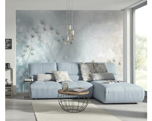 Svetlá obývacia izba s modrou pohovkou, konferenčným stolíkom a dekoratívnou nástennou tapetou