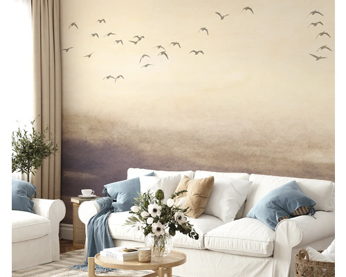 Obývacia izba s tapetou zobrazujúcou krajinu s vtákmi, pohovkou a dekoráciou