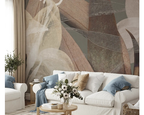 Obývacia izba s abstraktným listovým vzorom na stene za bielou pohovkou.