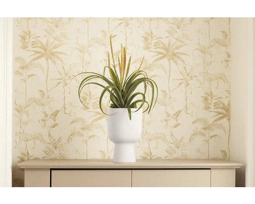 Dekoratívna umelá rastlina v bielom kvetináči na komode