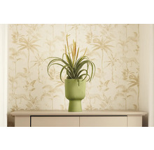 Dekoratívna umelá rastlina v rebrovanom kvetináči na komode pred vzorovanou tapetou