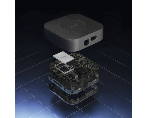 Rozložený pohľad na Philips Hue Bridge s krytom a vnútornou doskou plošných spojov s elektronickými súčiastkami.