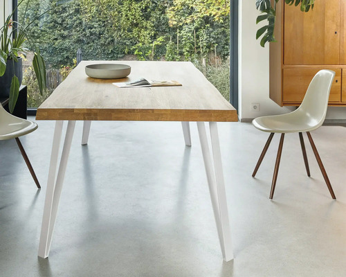 Jedálenský stôl s drevenou doskou a bielymi nohami v jedálni.