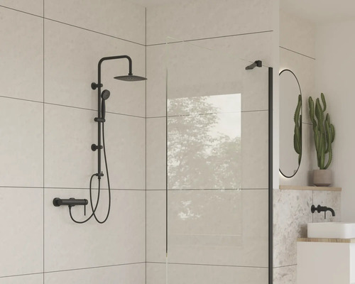 Moderná kúpeľňa s čiernou sprchovou súpravou, sprchovou zástenou a oválnym zrkadlom