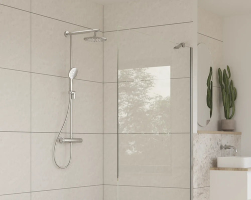 Sprchovací kút s hlavovou a ručnou sprchou vo svetlej kúpeľni