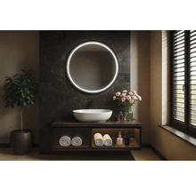 Kúpeľňa s okrúhlym zrkadlom s osvetlením, umývadlom a rastlinou