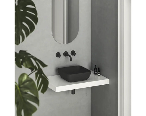 Moderná kúpeľňa s čiernym umývadlom na dosku, nástennou batériou a zrkadlom