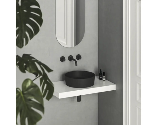 Moderná kúpeľňa s čiernym umývadlom na dosku, bielou policou a oválnym zrkadlom