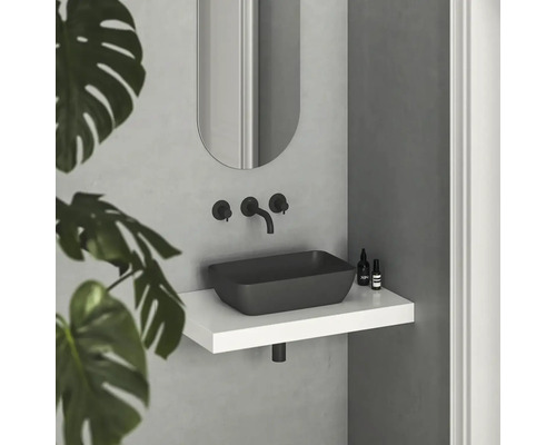 Moderná kúpeľňa s čiernym umývadlom na dosku, batériou a zrkadlom nad bielou policou