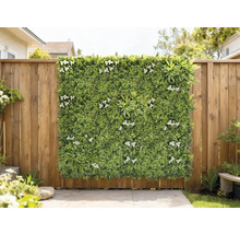 Dekoratívny zelený panel s bielymi kvetmi na drevenom plote