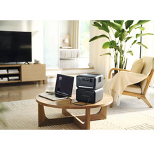 Prenosná napájacia stanica s notebookom na stole v obývacej izbe