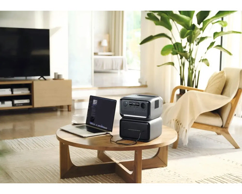 Prenosná napájacia stanica s notebookom na stole v obývacej izbe