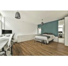 Svetlá spálňa s pracovným priestorom, posteľou, komodou a drevenou podlahou.