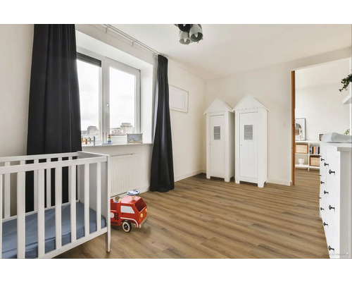 Svetlá detská izba s postieľkou, drevenou podlahou a dvoma bielymi skriňami v štýle plážového domu.