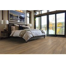 Spálňa s posteľou, lampou na nočnom stolíku, obrazom a drevenou podlahou