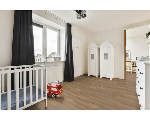 Svetlá detská izba s detskou postieľkou, drevenou podlahou a bielym nábytkom