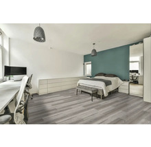 Svetlá spálňa s pracovným priestorom, posteľou, sivou podlahou a zodpovedajúcim osvetlením