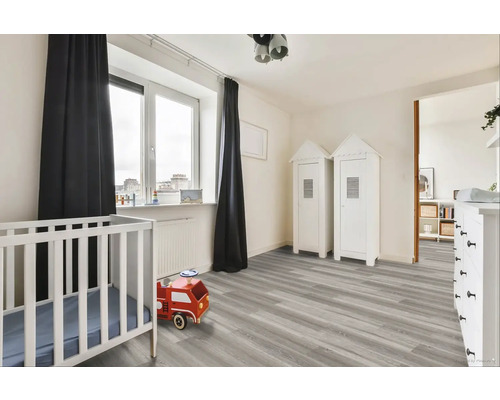 Svetlá detská izba s detskou postieľkou, hračkárskym hasičským autom a skriňami v tvare domu