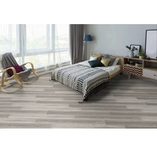 Spálňa s posteľou, kreslom a svetlou drevenou podlahou