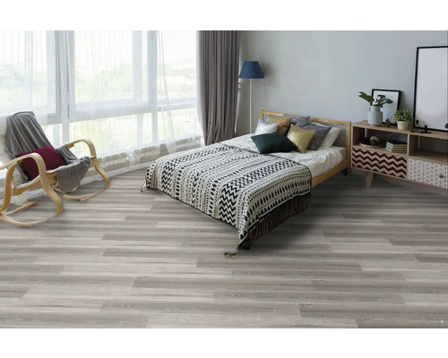 Spálňa s posteľou, kreslom a svetlou drevenou podlahou