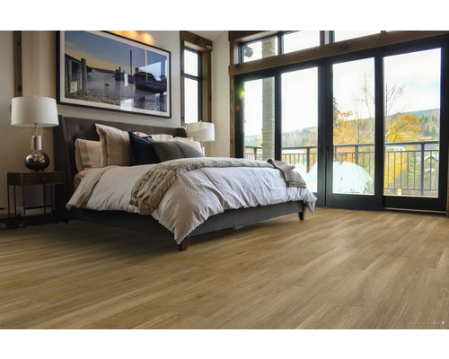 Spálňa s drevenou podlahou, posteľou a denným svetlom