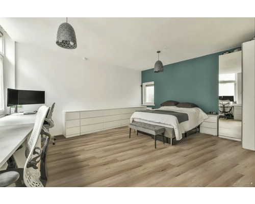 Spálňa s posteľou, písacím stolom a drevenou podlahou