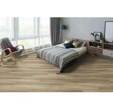 Spálňa so svetlou drevenou podlahou, posteľou, hojdacím kreslom a komodou