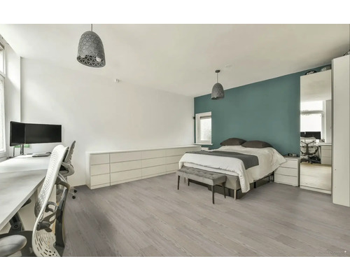 Moderná spálňa s posteľou, písacím stolom a svetlou drevenou podlahou