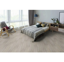 Spálňa so svetlou drevenou podlahou, posteľou, nočným stolíkom a hojdacím kreslom.