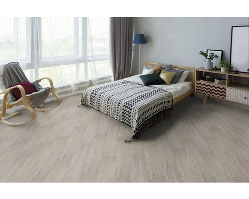 Spálňa so svetlou drevenou podlahou, posteľou, nočným stolíkom a hojdacím kreslom.