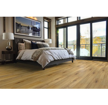 Spálňa s drevenou podlahou, posteľou, nočným stolíkom a oknami na balkón