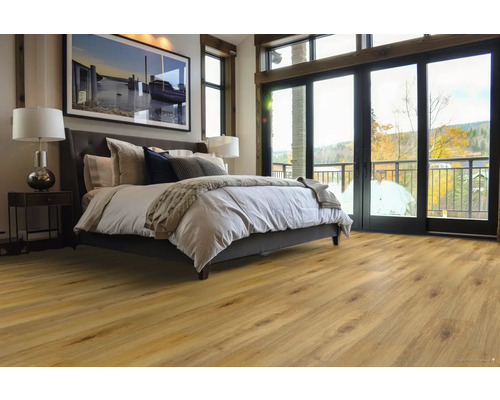 Spálňa s drevenou podlahou, posteľou, nočným stolíkom a oknami na balkón