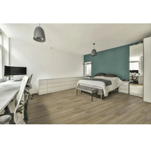 Svetlá spálňa s posteľou, písacím stolom a zodpovedajúcim nábytkom.