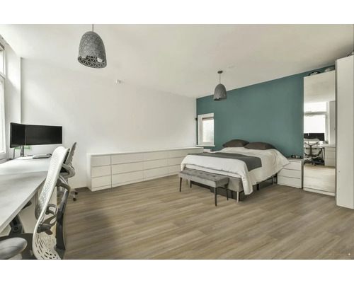 Svetlá spálňa s posteľou, písacím stolom a zodpovedajúcim nábytkom.