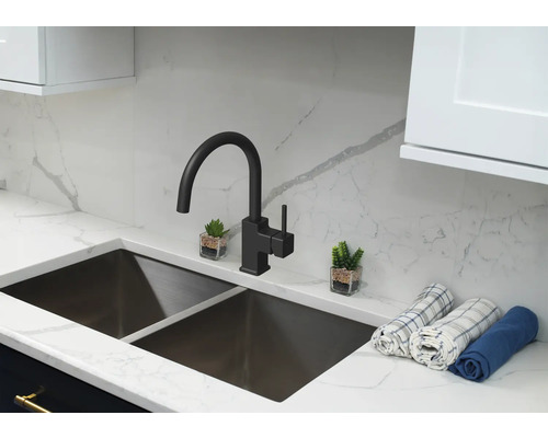 Kuchynský drez s vodovodnou batériou a dekoratívnymi prvkami na pracovnej doske.