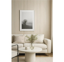 Obývacia izba s pohovkou, stolom a zarámovaným obrazom stromu