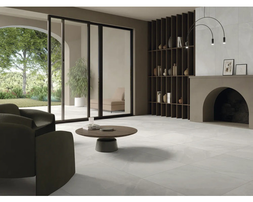 Svetlá obývacia izba s dlažbou, kreslom, konferenčným stolíkom a regálom