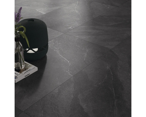 Dlaždicová podlaha s dekoratívnymi predmetmi a knihami.