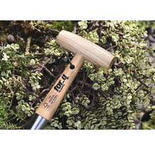 Záhradné náradie s drevenou rukoväťou a logom for-q, obklopené rastlinami