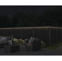 Záhradný nábytok na terase s osvetleným plotom v tme