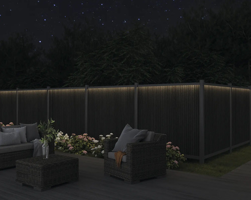 Záhradný nábytok na terase s osvetleným plotom v tme