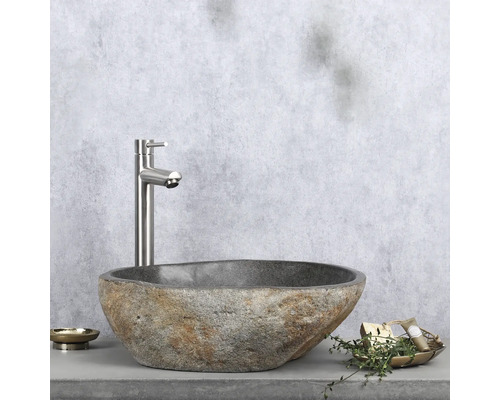 Umývadlo z prírodného kameňa s batériou na poličke s miskou na mydlo a dekoráciou