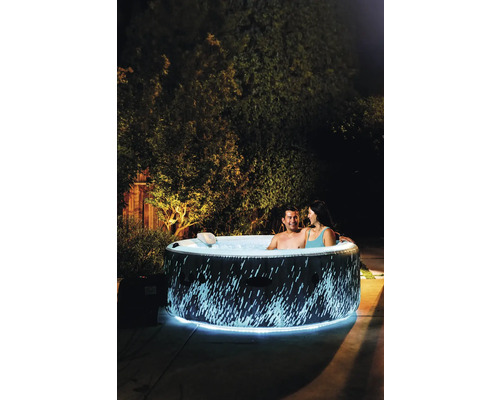 Nafukovacia vírivka s osvetlením a dvoma ľuďmi v záhrade