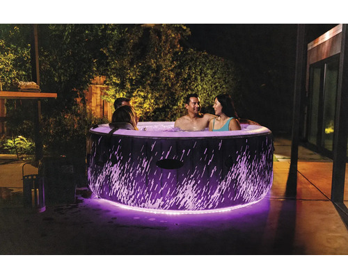 Nafukovacia vírivka s osvetlením a niekoľkými ľuďmi v záhrade