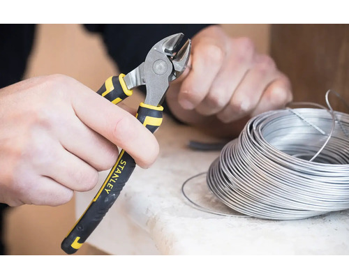 Osoba strihá drôt pomocou bočných štiepacích klieští značky Stanley.