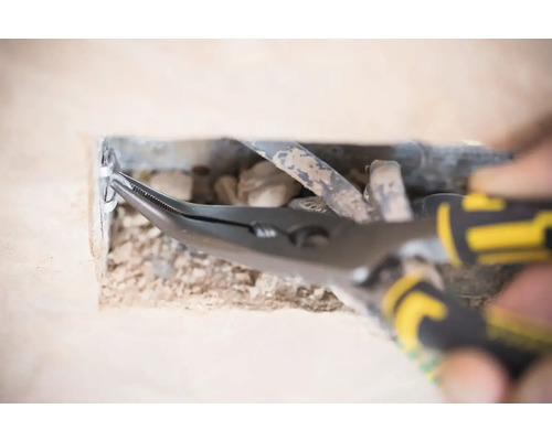 Kombinované kliešte v prevádzke na otvore vo stene s káblami